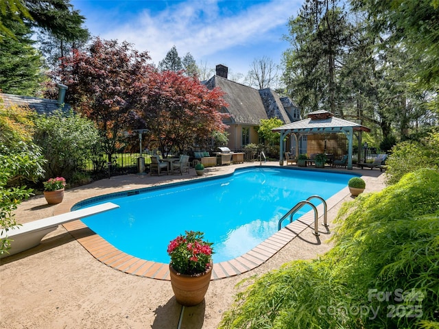 outdoor pool featuring a gazebo, a patio area, a diving board, and fence