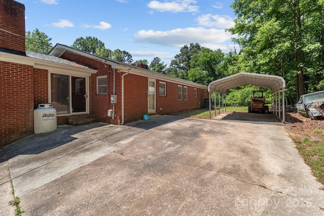 24501 Canton Rd, Albemarle, NC 28001 - view of side of home with a chimney, brick siding, a detached carport, and driveway