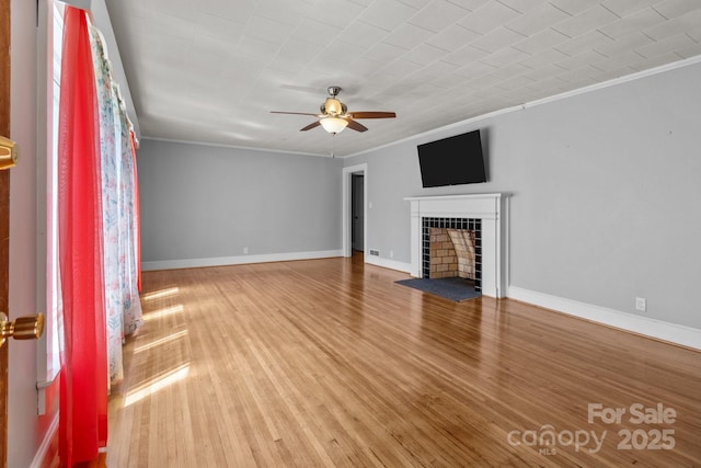 24501 Canton Rd, Albemarle, NC 28001 - unfurnished living room featuring ornamental molding, a ceiling fan, a fireplace, wood finished floors, and baseboards