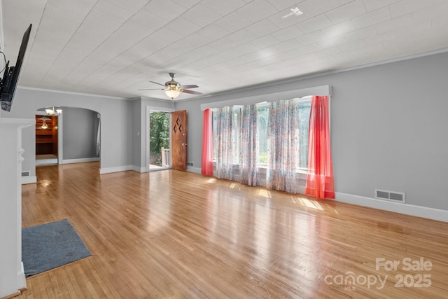 24501 Canton Rd, Albemarle, NC 28001 - unfurnished living room featuring arched walkways, ceiling fan, wood finished floors, baseboards, and crown molding