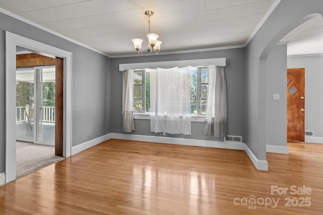 24501 Canton Rd, Albemarle, NC 28001 - spare room with crown molding, wood finished floors, arched walkways, baseboards, and a chandelier