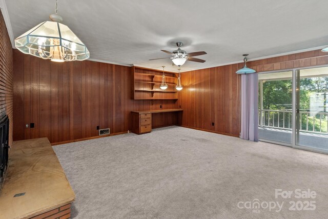 24501 Canton Rd, Albemarle, NC 28001 - unfurnished living room with wooden walls, ceiling fan, crown molding, carpet floors, and a fireplace