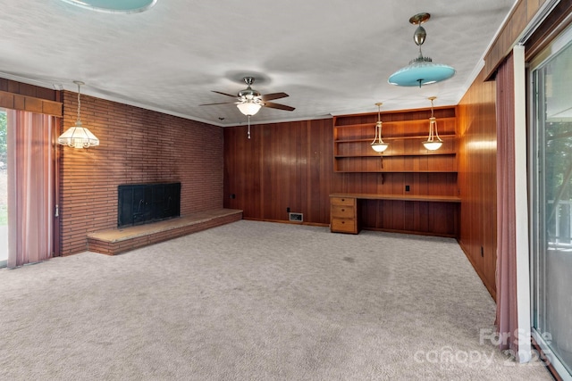 24501 Canton Rd, Albemarle, NC 28001 - unfurnished living room featuring wood walls, a ceiling fan, carpet flooring, and a fireplace