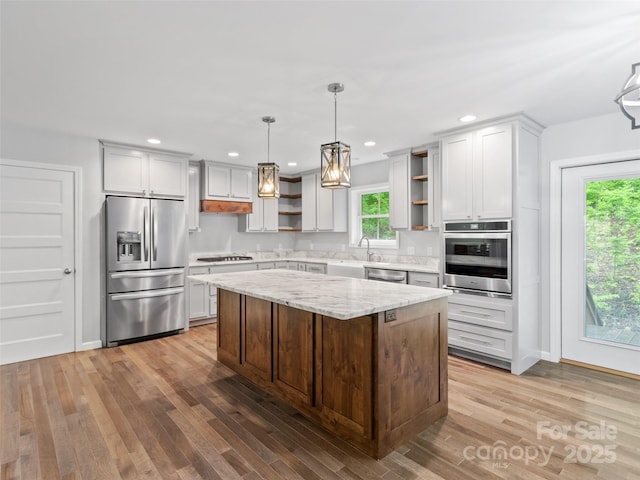 155 Pebble Ridge Rd, Spruce Pine, NC 28777 - kitchen featuring stainless steel appliances, open shelves, light wood-type flooring, a center island, and light stone counters