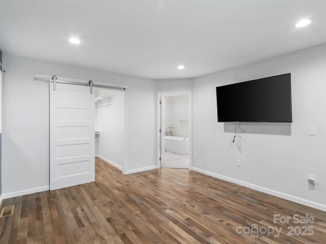 155 Pebble Ridge Rd, Spruce Pine, NC 28777 - unfurnished living room featuring a barn door, recessed lighting, wood finished floors, and baseboards