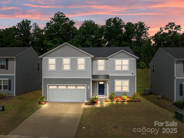 traditional-style house featuring an attached garage, driveway, a front lawn, board and batten siding, and central AC