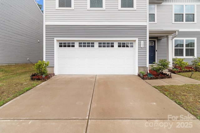 view of front of house featuring concrete driveway and an attached garage