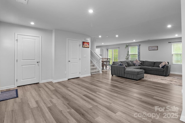 living area featuring recessed lighting, light wood finished floors, plenty of natural light, and baseboards