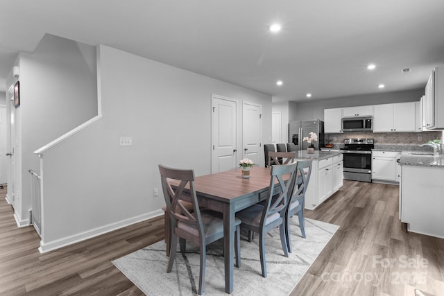 dining room featuring dark wood-style flooring, recessed lighting, and baseboards