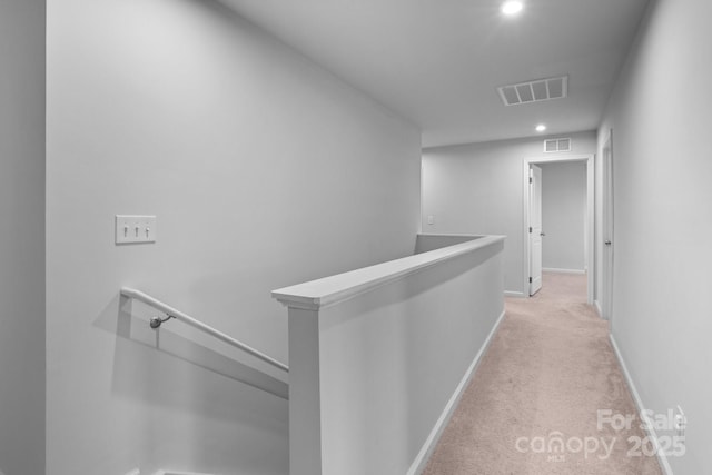 hallway with an upstairs landing, light carpet, recessed lighting, and baseboards