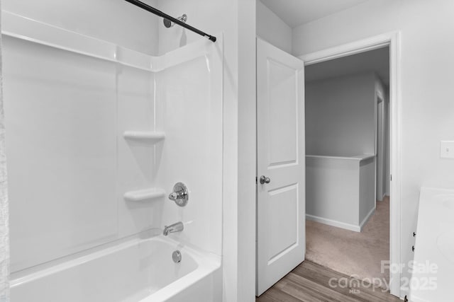 bathroom with wood finished floors, shower / washtub combination, and baseboards