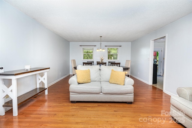 3049 Stablegate Dr, Gastonia, NC 28052 - living area featuring light wood-style flooring, a chandelier, and baseboards