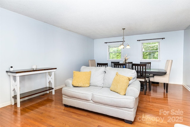 3049 Stablegate Dr, Gastonia, NC 28052 - living area with light wood-type flooring, baseboards, and a chandelier