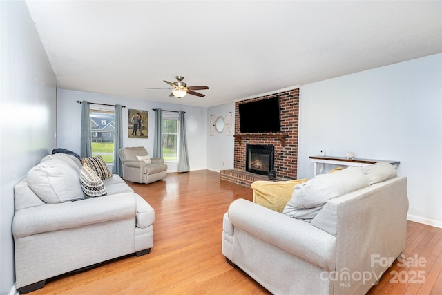 3049 Stablegate Dr, Gastonia, NC 28052 - living area featuring ceiling fan, light wood-type flooring, a fireplace, and baseboards