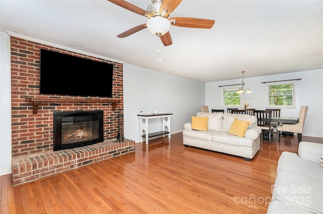 3049 Stablegate Dr, Gastonia, NC 28052 - living room featuring wood finished floors, a ceiling fan, a fireplace, and baseboards
