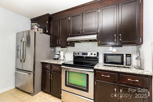 3049 Stablegate Dr, Gastonia, NC 28052 - kitchen featuring appliances with stainless steel finishes, under cabinet range hood, decorative backsplash, light tile patterned flooring, and light stone counters
