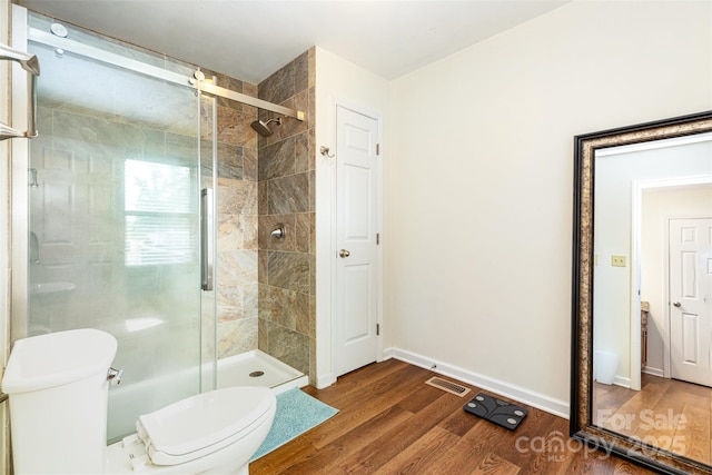 3049 Stablegate Dr, Gastonia, NC 28052 - bathroom featuring a shower stall, toilet, wood finished floors, and baseboards