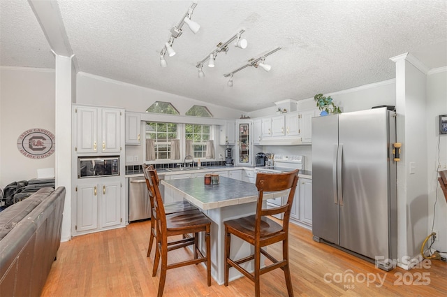 403 Carpenter Parker Ln, Rock Hill, SC 29730 - kitchen featuring stainless steel appliances, lofted ceiling, white cabinets, light wood-style flooring, and a textured ceiling
