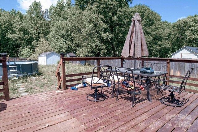 305 Ridge Manor Dr, Raeford Township, NC 28376 - wooden deck featuring a storage unit, an outbuilding, and outdoor dining area