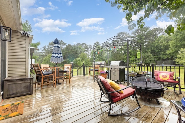 2906 Chapman Cir, Rock Hill, SC 29732 - wooden terrace with outdoor dining area, a trampoline, an outdoor living space with a fire pit, a grill, and view of scattered trees