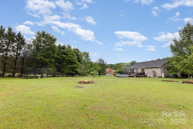 2906 Chapman Cir, Rock Hill, SC 29732 - view of grassy yard featuring a trampoline, a fire pit, a storage shed, an outdoor structure, and a wooden deck