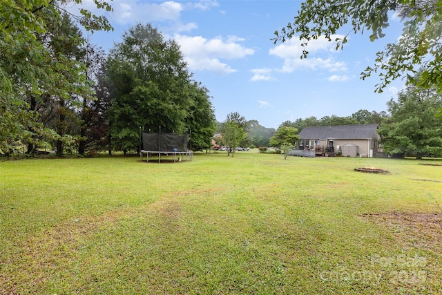 2906 Chapman Cir, Rock Hill, SC 29732 - view of green lawn featuring a trampoline, a fire pit, and a wooden deck