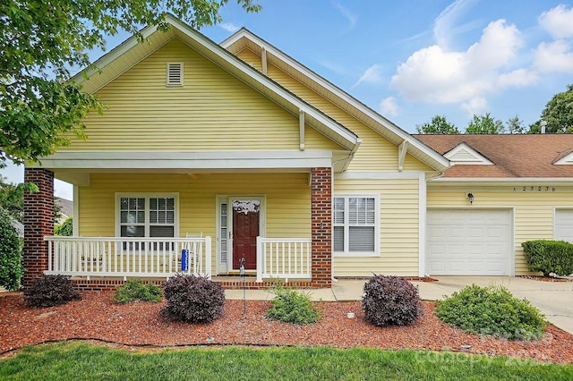 view of front of property featuring covered porch, a garage, and driveway