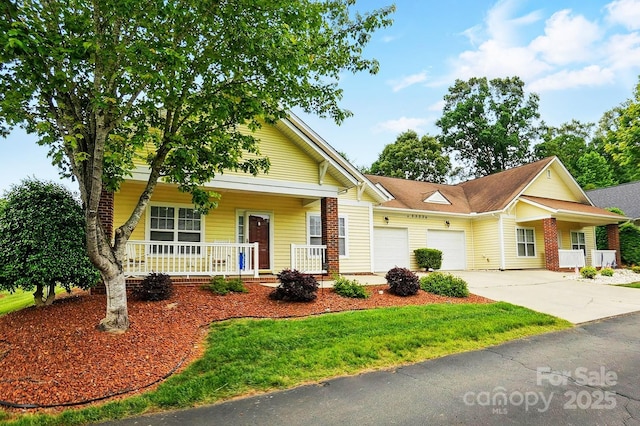 view of front of property with covered porch, an attached garage, driveway, and a front yard