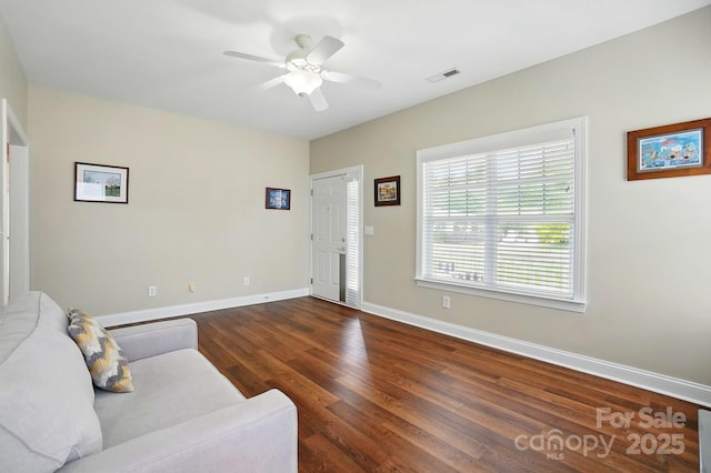 living area with wood finished floors, baseboards, and ceiling fan