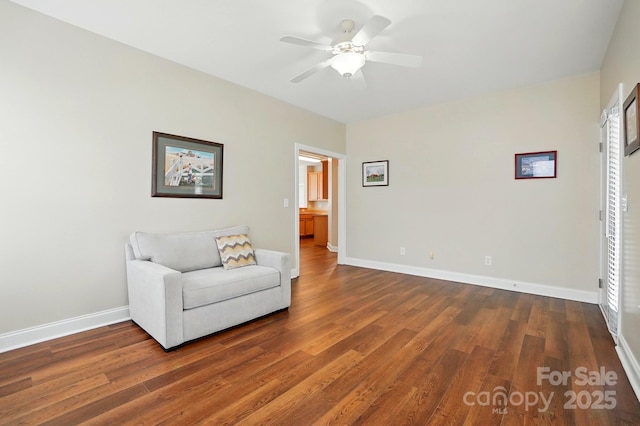 sitting room with wood finished floors, ceiling fan, and baseboards