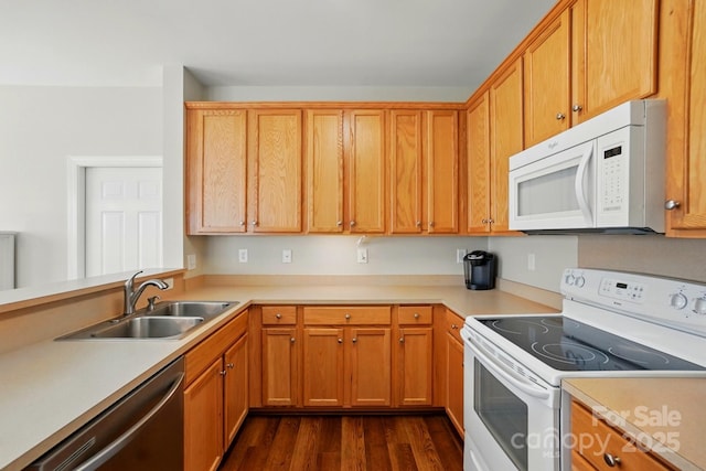 kitchen featuring white appliances, a sink, light countertops, and dark wood-type flooring