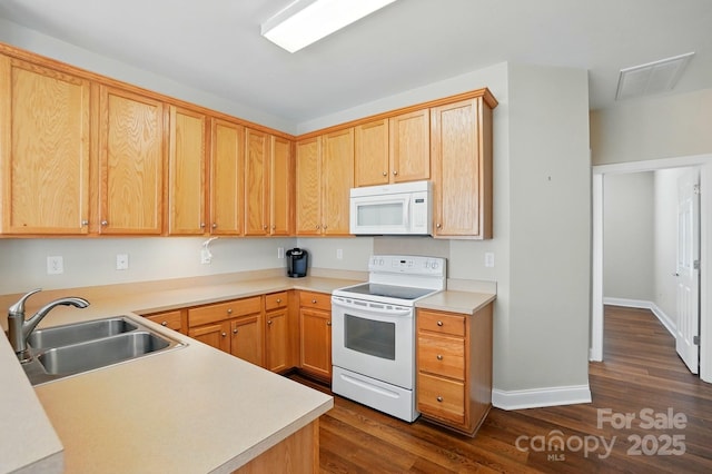 kitchen featuring white appliances, a sink, dark wood finished floors, baseboards, and light countertops