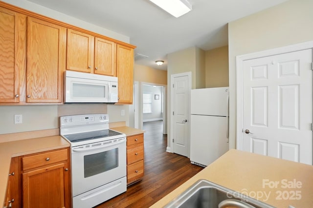 kitchen featuring white appliances, dark wood-style flooring, and light countertops