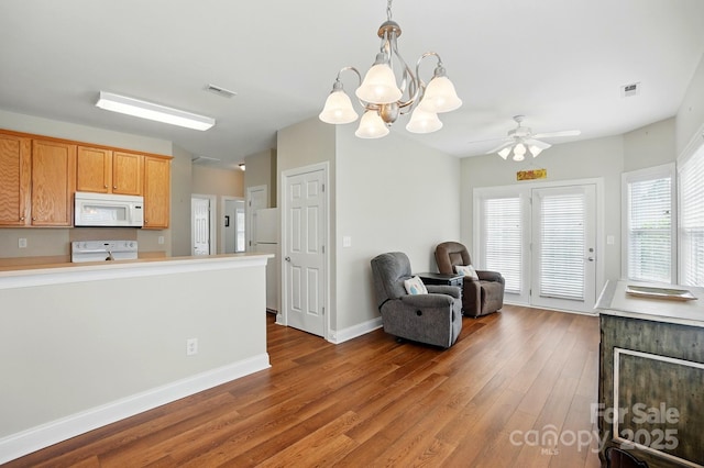 sitting room with wood finished floors, a chandelier, a ceiling fan, and baseboards