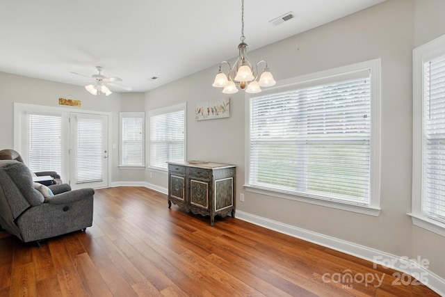 sitting room with hardwood / wood-style flooring, baseboards, a chandelier, and plenty of natural light