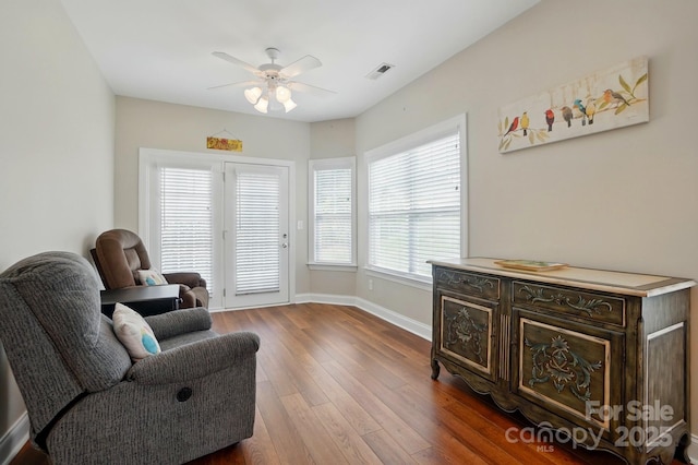 sitting room featuring a ceiling fan, hardwood / wood-style floors, and baseboards