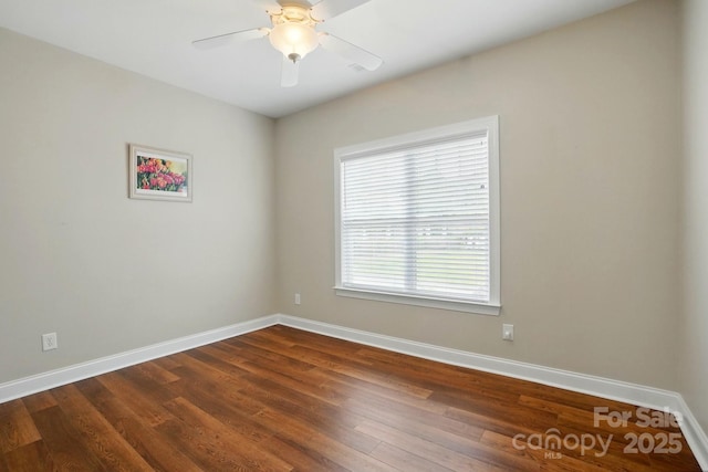 unfurnished room with baseboards, dark wood-style floors, and ceiling fan