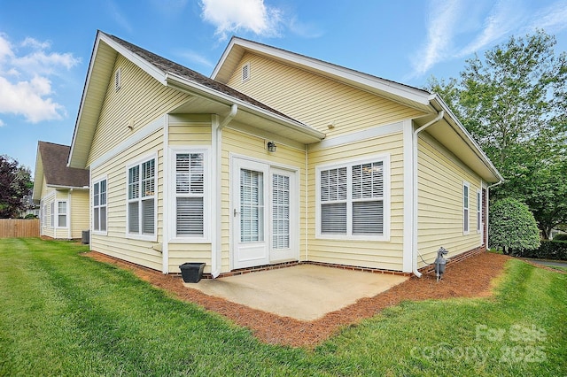 back of house with a patio area and a lawn