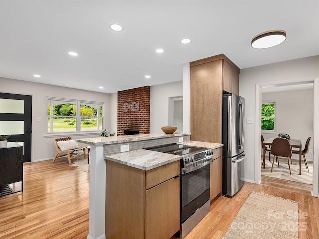 16 Emerson Poore Dr, Candler, NC 28715 - kitchen featuring stainless steel appliances, a brick fireplace, healthy amount of natural light, light wood-style flooring, and recessed lighting