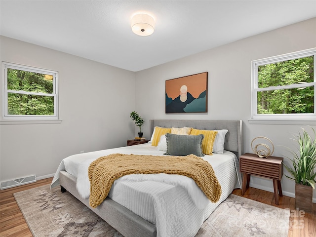 16 Emerson Poore Dr, Candler, NC 28715 - bedroom with multiple windows, wood finished floors, and baseboards