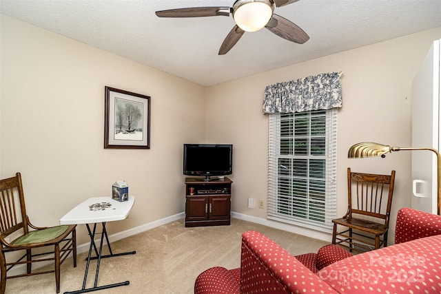 carpeted living room featuring a ceiling fan and baseboards