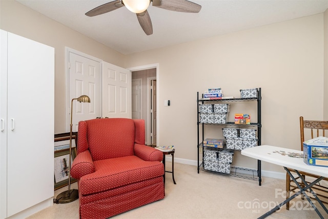 sitting room featuring ceiling fan, carpet flooring, and baseboards
