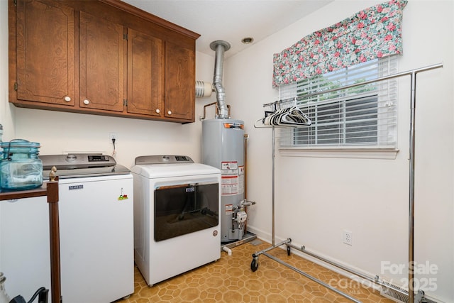 washroom featuring cabinet space, water heater, and washing machine and clothes dryer