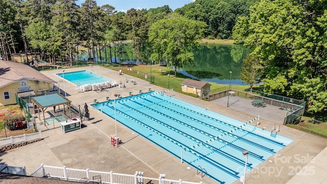 community pool featuring a water view and fence