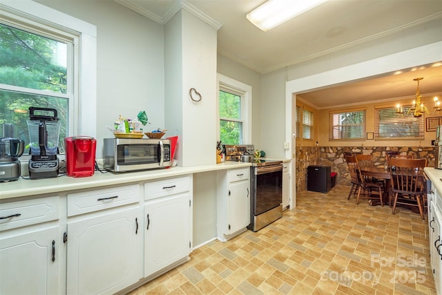 223 Assembly Dr, Montreat, NC 28757 - kitchen with stainless steel appliances, brick patterned flooring, a chandelier, white cabinetry, and crown molding