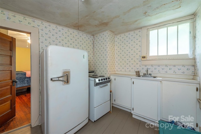 223 Assembly Dr, Montreat, NC 28757 - kitchen with white appliances, wallpapered walls, a sink, light countertops, and white cabinets
