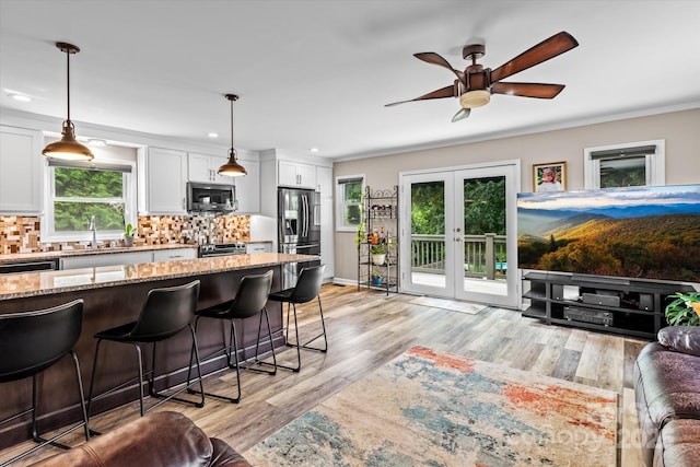 147 Bluewing Ln Unit 274, Mooresville, NC 28117 - kitchen featuring appliances with stainless steel finishes, a kitchen breakfast bar, light stone counters, a sink, and white cabinetry