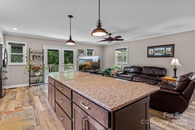 147 Bluewing Ln Unit 274, Mooresville, NC 28117 - kitchen featuring freestanding refrigerator, ceiling fan, light wood-style floors, french doors, and a kitchen island