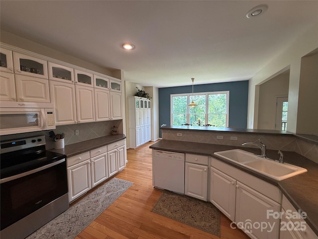 357 Lentz Landing Ln, Nebo, NC 28761 - kitchen with white appliances, light wood-type flooring, dark countertops, white cabinetry, and recessed lighting