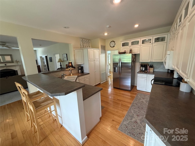 357 Lentz Landing Ln, Nebo, NC 28761 - kitchen with stainless steel fridge with ice dispenser, dark countertops, white microwave, light wood-style floors, and glass insert cabinets